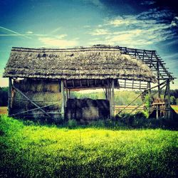 Barn on grassy field against sky