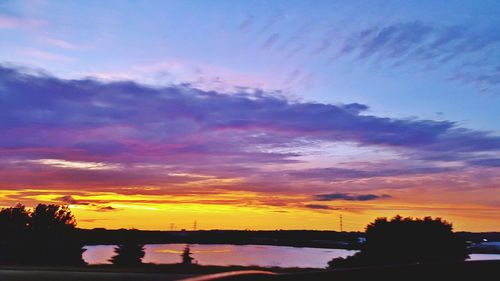 Scenic view of river against romantic sky at sunset