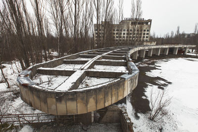 View of frozen river against bare trees during winter