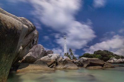 Rock formations by sea against sky