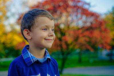 Close-up of smiling boy looking away