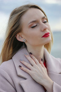  portrait of a beautiful young woman with red lips on the sea