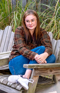 A high school senior poses in casual clothing for an outdoor portrait