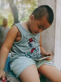 Boy sitting with mobile phone