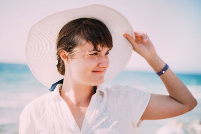 Side view of woman wearing hat against clear sky