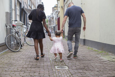 A young couple walking with their daughter