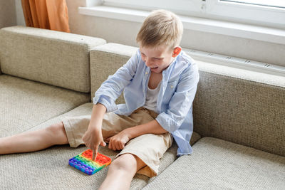 Boy sitting on sofa at home