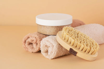 Salt scrub and natural brush for dry massage on a beige background. beauty, spa and wellness concept