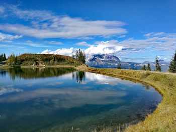 Scenic view of lake and mountains against blue sky