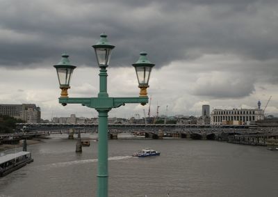 Street light by buildings against sky