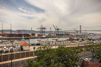 High angle view of cranes at harbor against sky