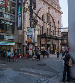 People walking on street against buildings in city