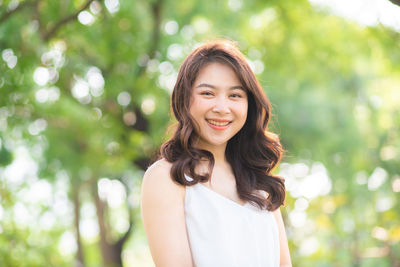 Portrait of smiling woman standing in park