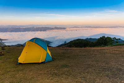 Tent on field against sky during sunset