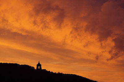 Silhouette man standing against orange sky