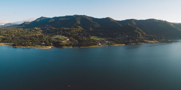 Scenic view of sea and mountains against clear sky