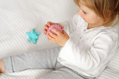 Baby girl playing tactile knobby balls. young child hand plays sensory massage ball