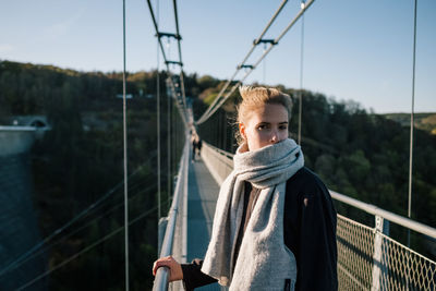 Portrait of woman on footbridge against sky