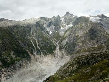 Scenic view of waterfall and mountains against sky