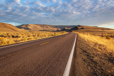 Scenic view of road by land against sky