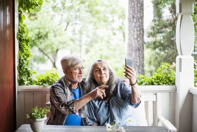 Senior couple taking selfie in porch
