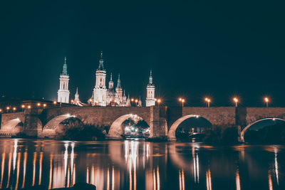 Illuminated buildings in water at night