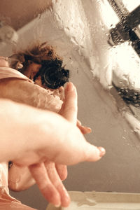 Midsection of woman hand on wet glass