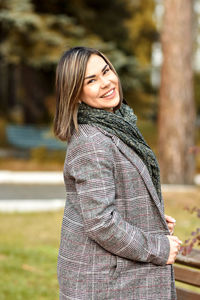 Portrait of a young woman in casual plus size clothing against a background of yellow foliage