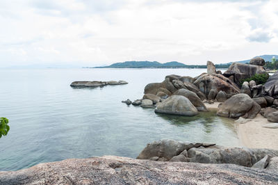 Rocks on sea shore against sky