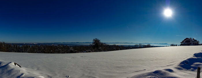 Snow covered land against blue sky