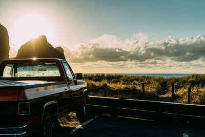 Car on road against sea during sunset