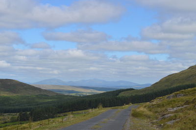 Road leading towards mountains against sky