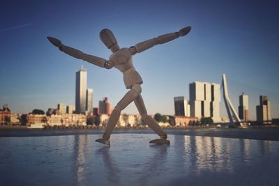 Man jumping in city against clear sky