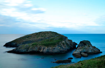 Rocks in sea against sky