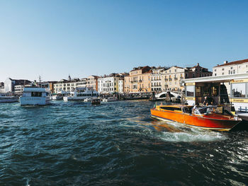 View of sea and buildings against clear sky