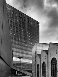 Low angle view of modern building against cloudy sky