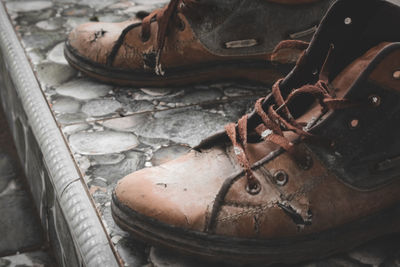 A pair of brown shoes that have been damaged and not maintained