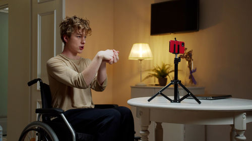 Young man exercising while vlogging at home