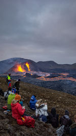 Hikers watch a volcanic eruption in mt fagradalsfjall, southwest iceland, in march 2021.