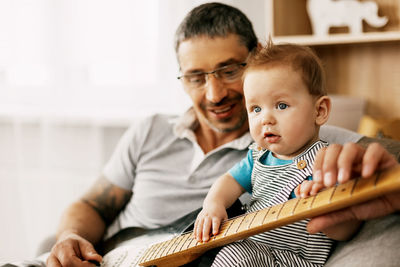Smiling father with baby with guitar