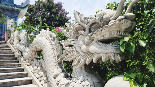 Statue amidst white flowers against building