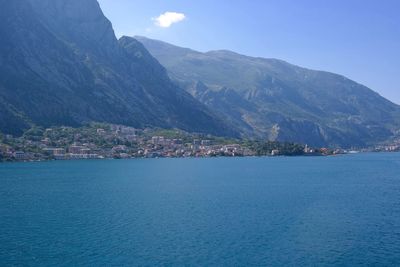 Scenic view of sea and mountains against blue sky