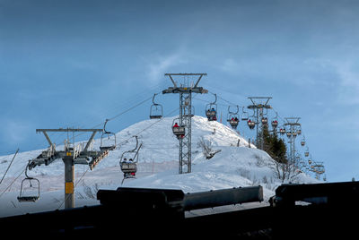 Snow covered cranes against sky