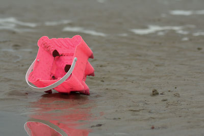 Close-up of red umbrella on beach