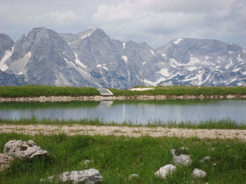 Scenic view of lake by mountains against sky