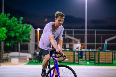 Man cycling at illuminated park during night