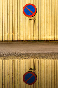 No parking zone sign reflected in puddle