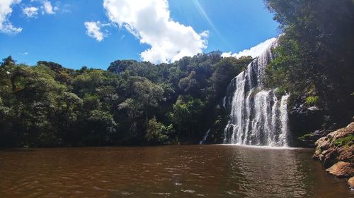 Scenic view of waterfall against sky