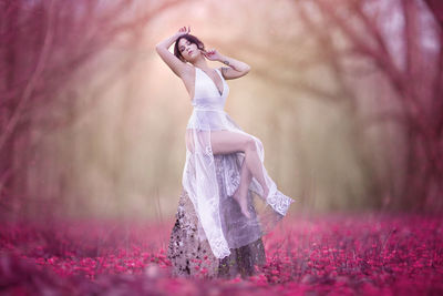 Full length of woman standing on pink umbrella