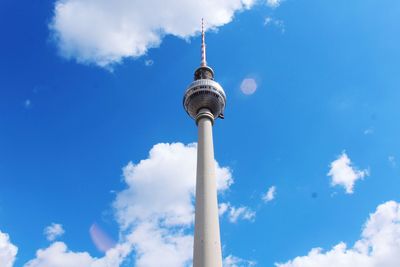 Low angle view of communications tower and building against sky